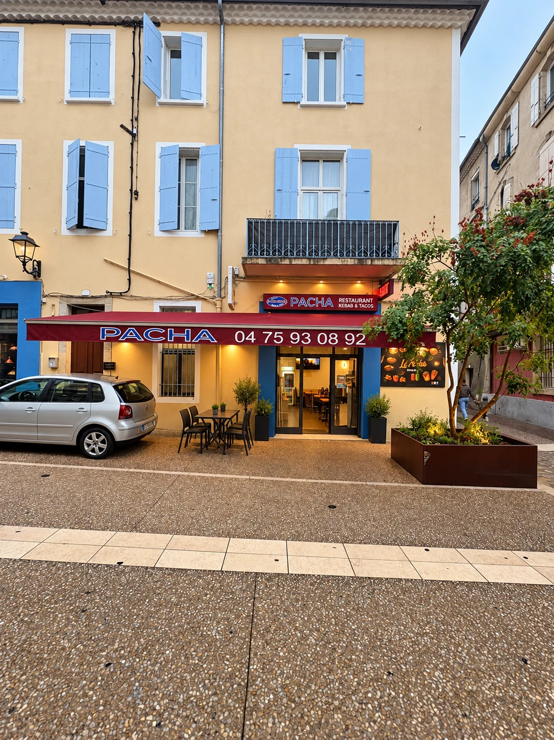 Façade bordeaux et bleue du restaurant Le Pacha et sa terrasse